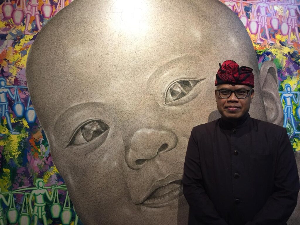 I Wayan Kun Adnyana, Kepala Dinas Kebudayaan Provinsi Bali, berfoto didepan lukisannya yang berjudul New Passion.