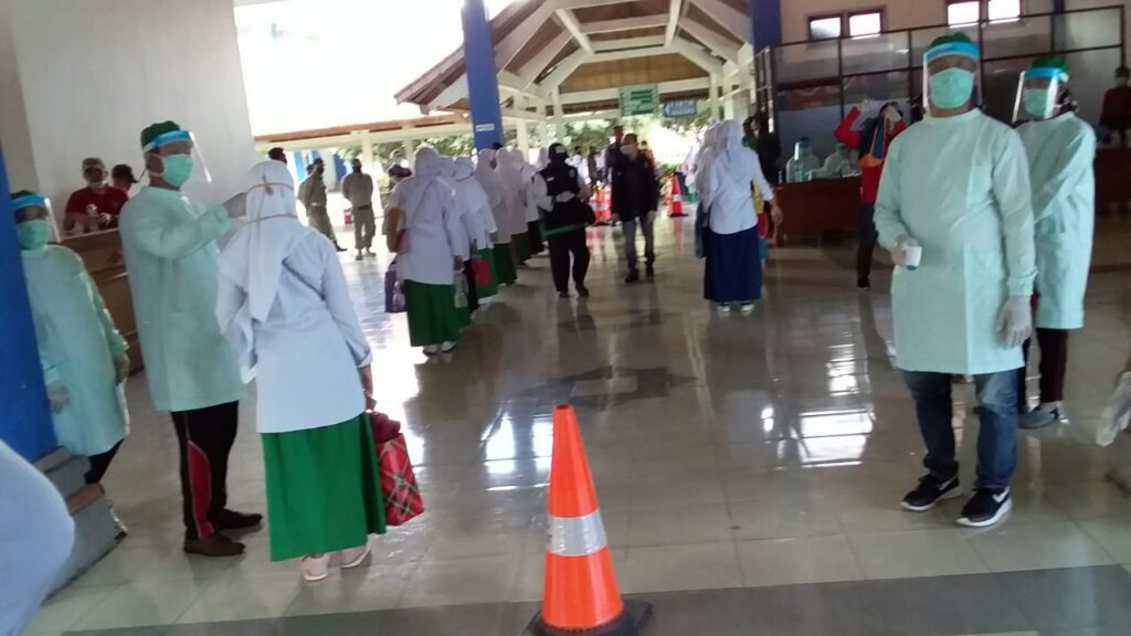 Para santri yang tiba di Terminal Mengwi langsung memasuki ruang sterilisasi dengan penyemprotan cairan disinfektan dan pengukuran suhu tubuh.