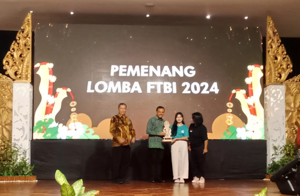 Sekda Dewa Made Indra menyerahkan piala kepada pemenang salah satu kategori di Festival Tunas Bahasa Ibu 2024.